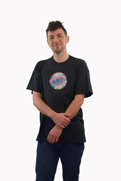 A circular image of technicolor clouds with a blue butterfly in the center glitter printed on a black t-shirt, worn by a white man.