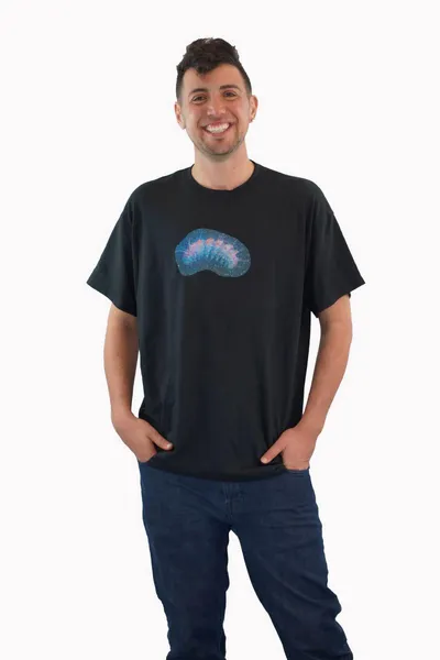 A technicolor caterpillar on a dark blue background glitter printed on a black t-shirt, worn by a white man.