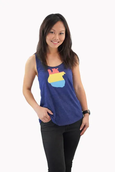 The pansexual flag in the shape of an anatomical heart printed on a dark blue tank top, worn by a young asian woman.